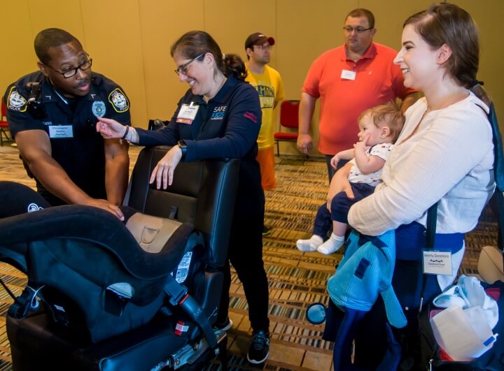 Technicians discuss getting infants safely in car seats.