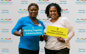 Attendees-pose-with-signs-in-front-of-Childrens-Trust-banner - Children's Trust of South Carolina Attendees-pose-with-signs-in-front-of-Childrens-Trust-banner