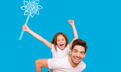 Young girl on her dads back holding a pinwheel over her head