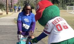 Greenville Drive Mascot, Reedy, greets a mother and child during a Child Champions Classic.