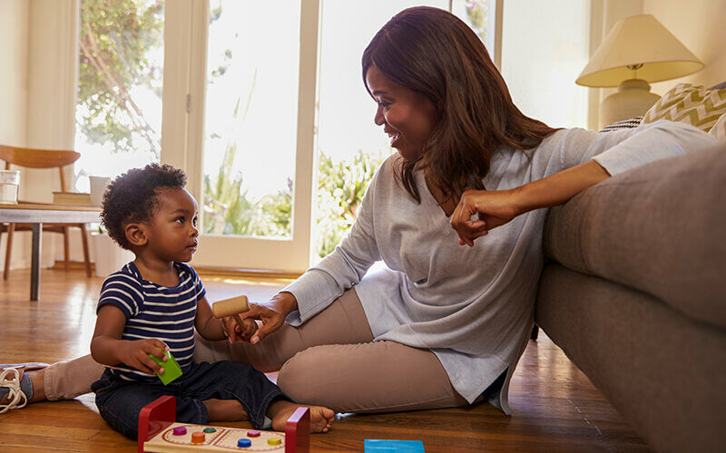Mother And Son Playing With Toys On Floor at Home 800x0 c default