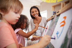 Teacher-at-school-helping children in art class.