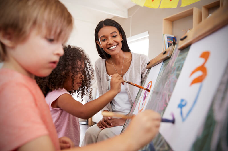 Teacher-at-school-helping children in art class.