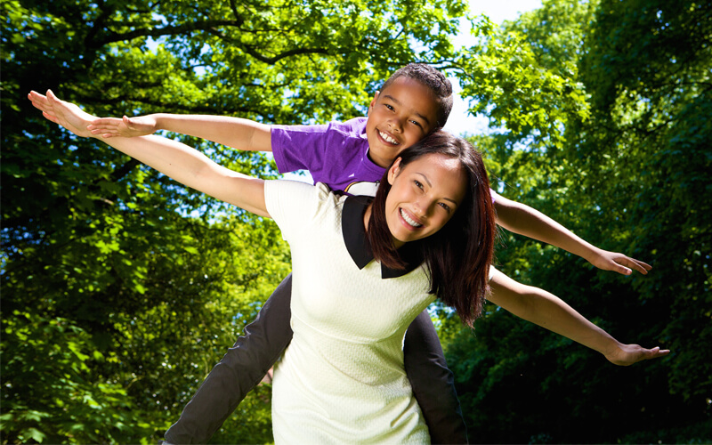 Young-mother-and-son-with-arms-spread