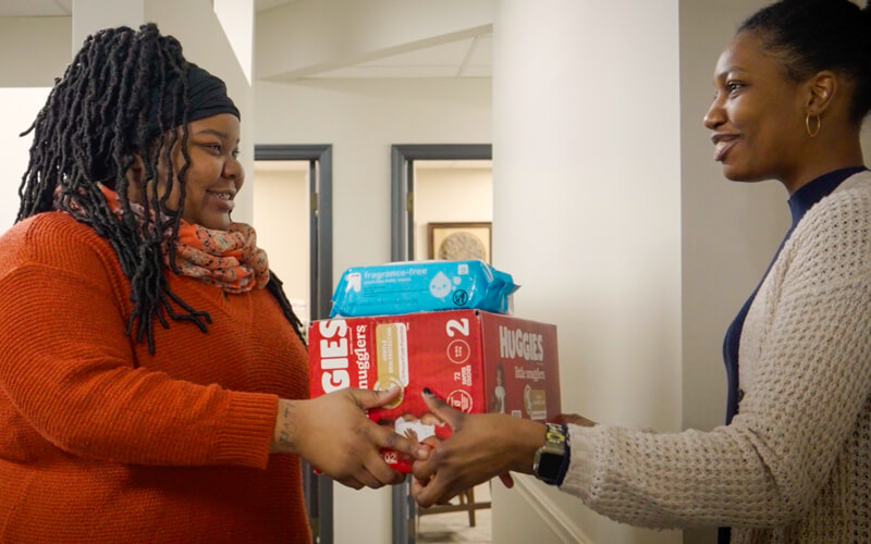 Parent receiving free diapers at a family resource center.