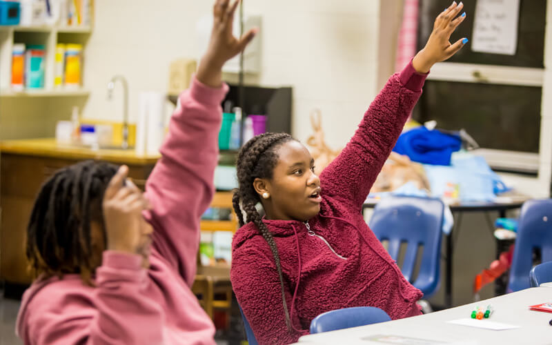 Two young girls raise their hands during an SFP session in Hartsville.