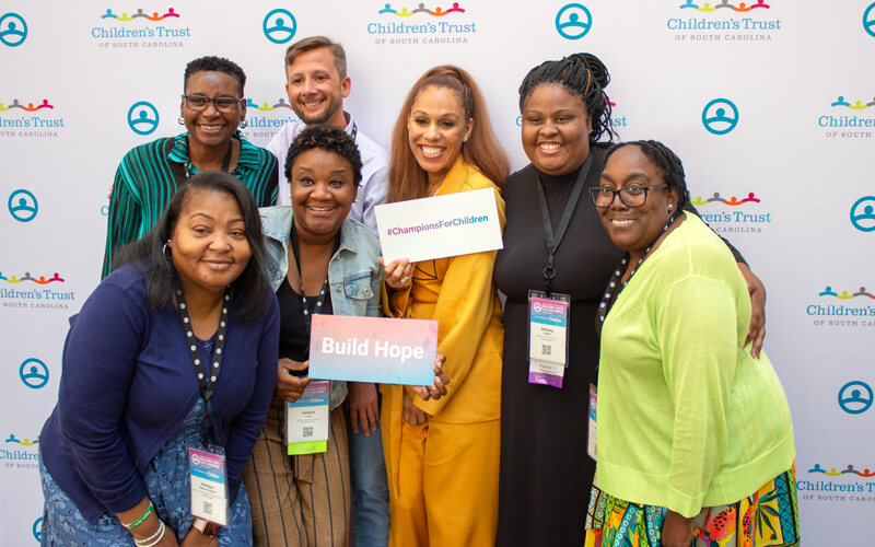 Attendees in front of the step and repeat at the Building Hope for Children Conference 2024.
