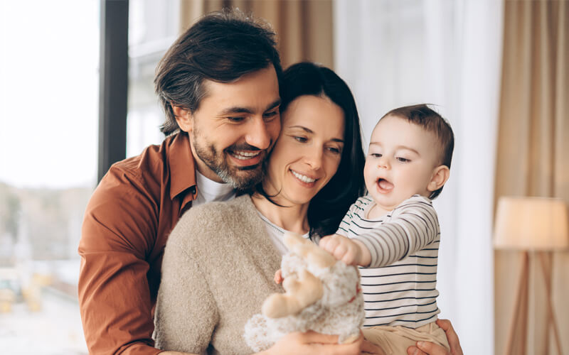 Happy-family-playing-with-teddy-bear-at-home