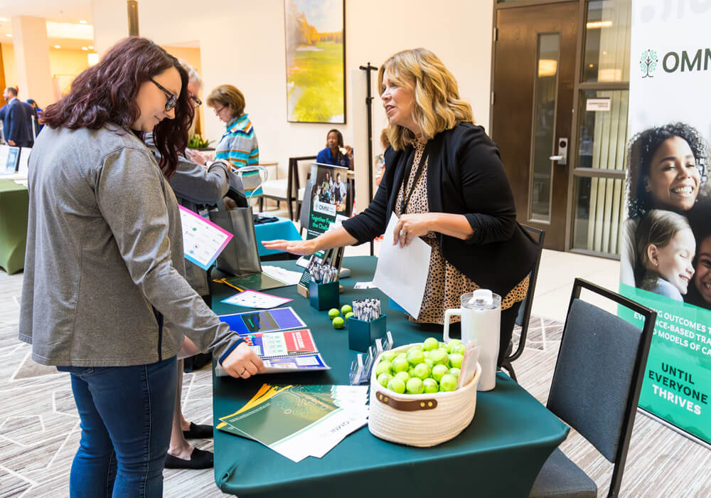 Attendee visits an exhibitor table at the 2024 Building Hope for Children Conference.
