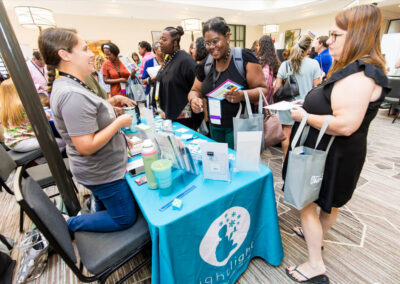 Attendees visit an exhibitor table at the 2024 Building Hope for Children Conference.