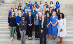 Childrens Trust Staff, wearing blue, stands on steps of the State House