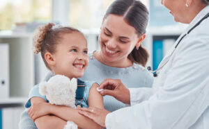 Doctor-using-a-cotton-ball-on-a-little-girls-arm-while-administering-an-injection-in-a-clinic.