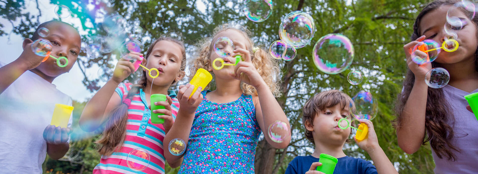 Kids blowing bubbles in park